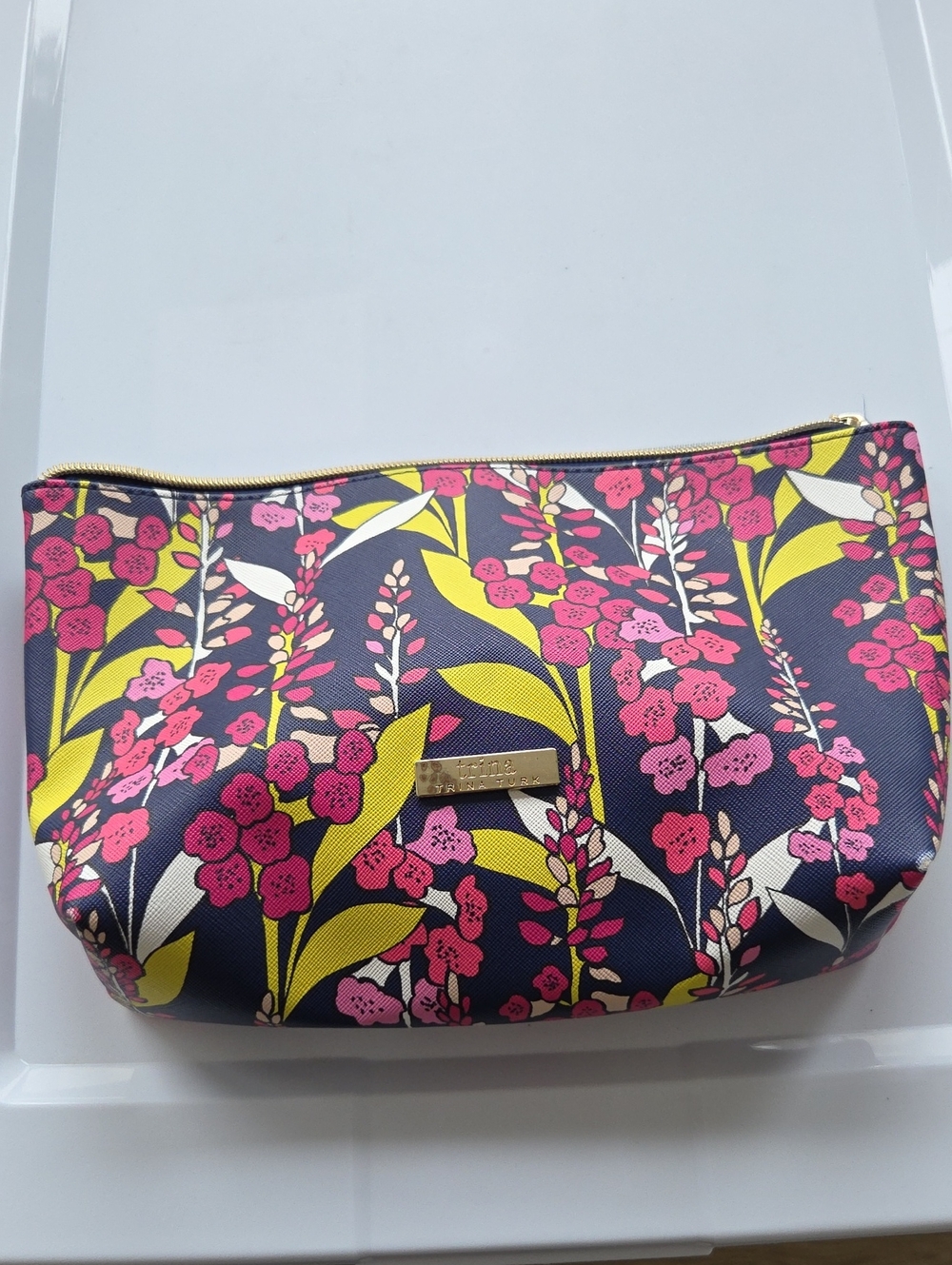Trina Turk navy floral cosmetic pouch with pink and yellow blooms